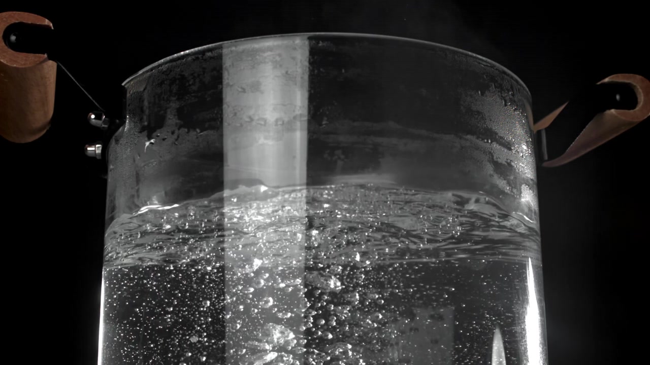 Primo piano di acqua in ebollizione in una pentola di vetro trasparente
