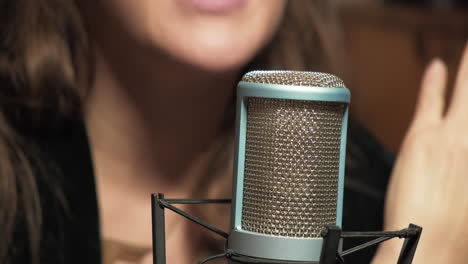 Woman-radio-host-sitting-at-microphone-and-having-talk-on-air-about-news