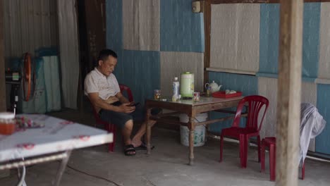 Man Sitting and Relaxing at Small Shop