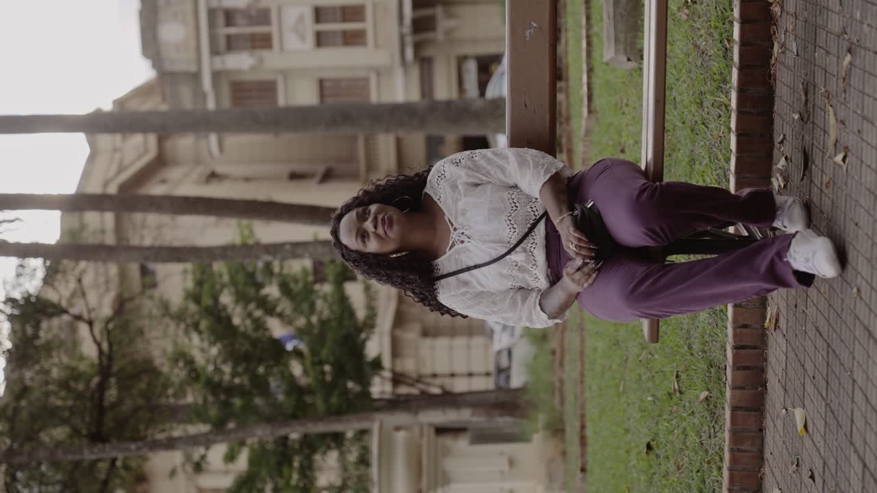 Woman sitting and smiling on a park bench