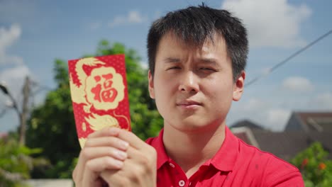 chinese lucky man holding hongbao red packet