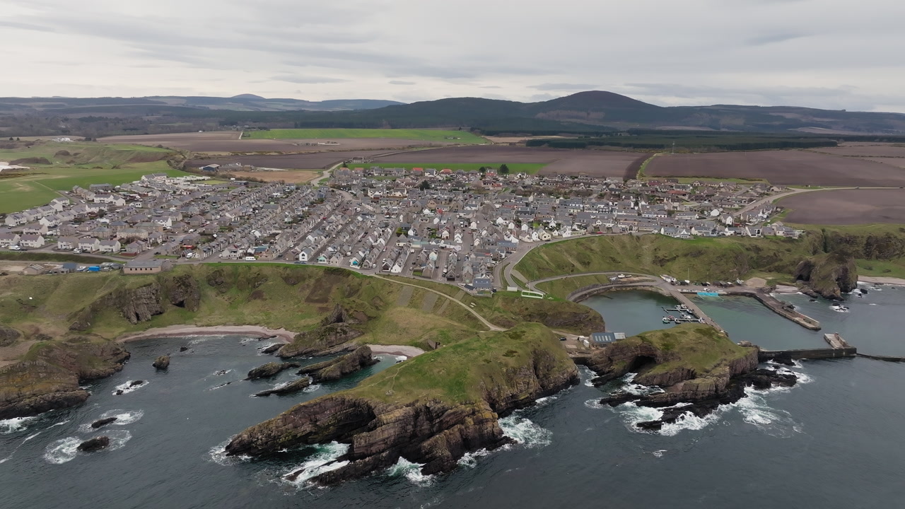Aerial pullback shot of Scottish fishing village Portknockie, Scotland