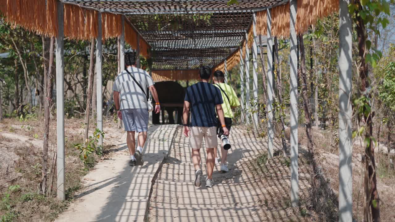 People walking on a pergola-covered path