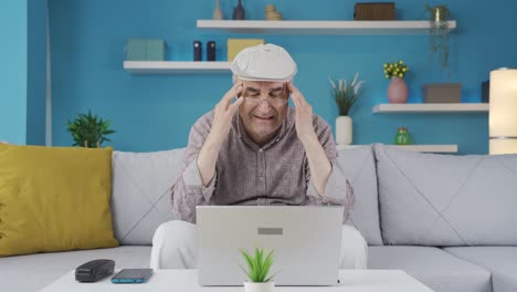 old man using laptop has a headache.