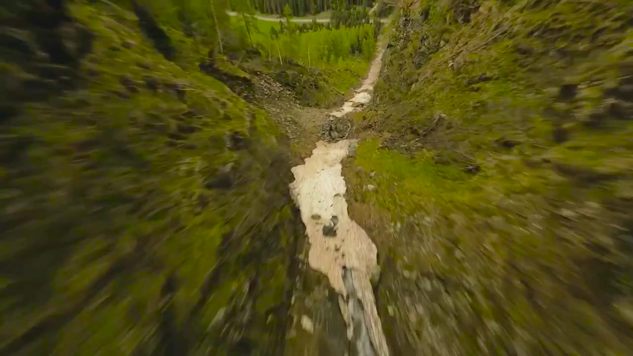 Drone aereo FPV che vola dall'alto tra le montagne e vicino al suolo durante una splendida giornata estiva o autunnale. Neve bianca e intatta si trova tra le vette.
