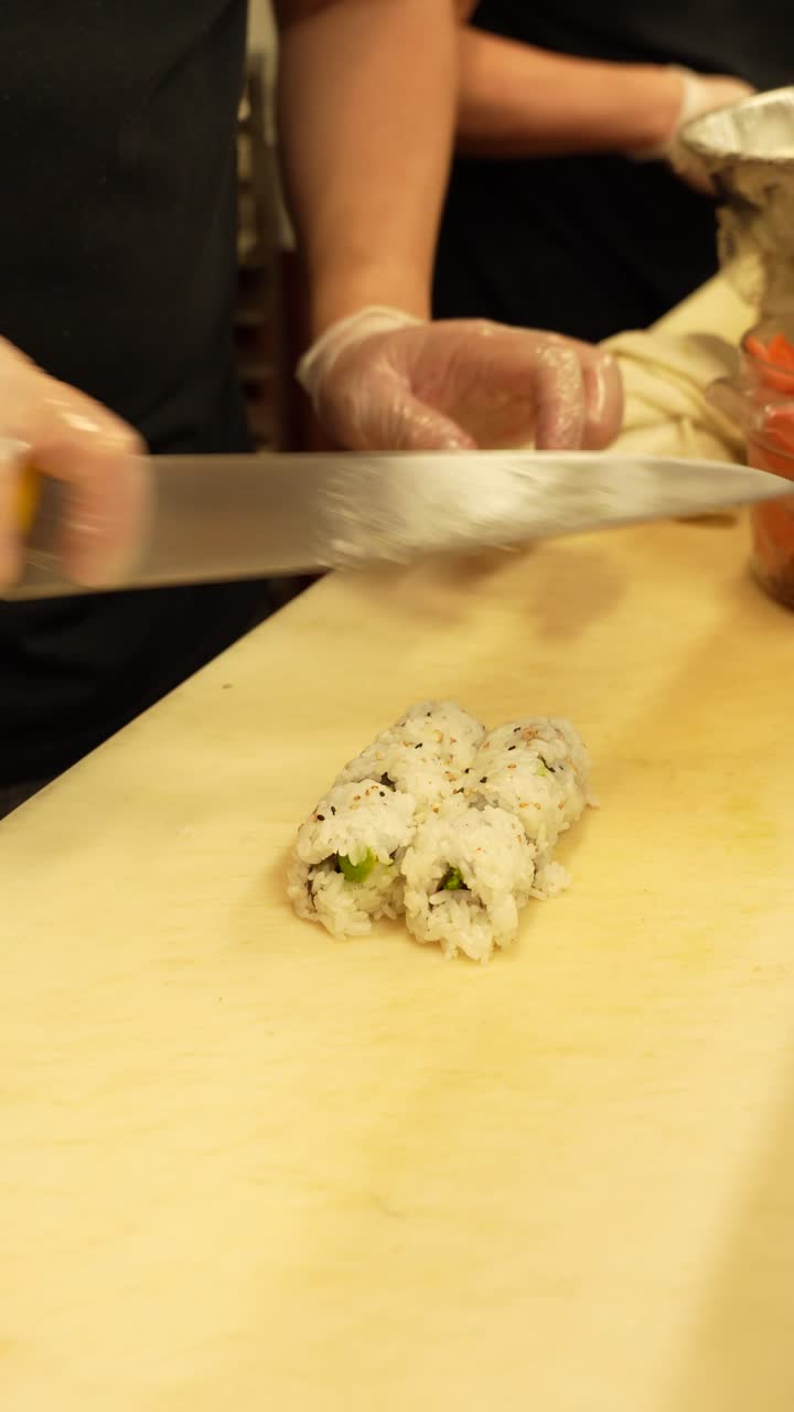 Chef rolls and cuts sushi in a Japanese restaurant