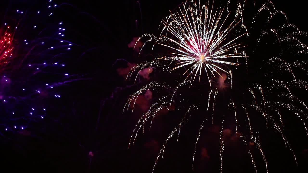 coloridos fuegos artificiales explotando en el cielo nocturno. celebraciones y eventos en colores brillantes.