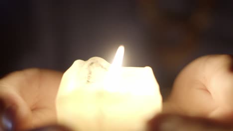 golden bright candle light between the hands.