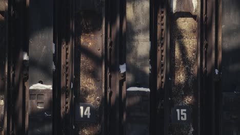 dos viejos almacenes metálicos cerrados y oxidados con los números 14 y 15 que muestran signos de edad