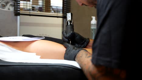 pull in shot of an artist working with a wireless tattoo pen machine