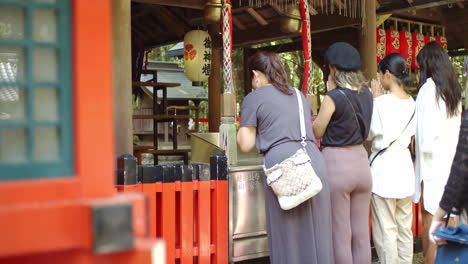 Praying-in-front-of-a-shrine-in-Kyoto,-Japan-soft-lighting-slow-motion