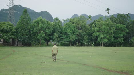 man walking through a rural landscape