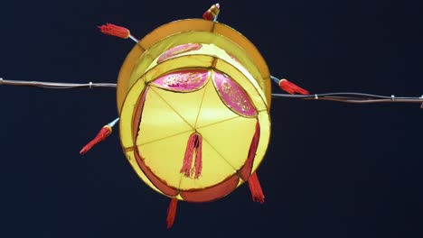 a chinese yellow lantern, which symbolize prosperity and good fortune, hangs from a wire during the mid-autumn festival, also called mooncake festival