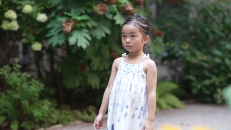 little girl raising her arms and pointing with her fingers, outdoor model