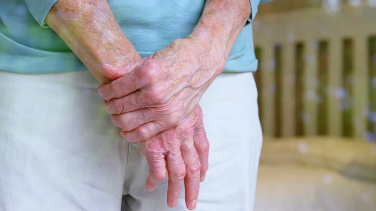 Anziana in piedi con le mani giunte a casa 4K