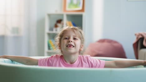 Cute-girl-with-toothless-smile-plays-with-plastic-balls