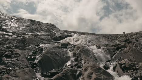 FPV-Drohnenaufnahmen,-Die-Im-Sommer-Einen-Gletscherbach-Vom-Kitschteinhorn-Gletscher-In-Kaprun-Hinauffliegen-Und-Die-Auswirkungen-Der-Globalen-Erwärmung-Durch-Schmelzendes-Eis-Hervorheben