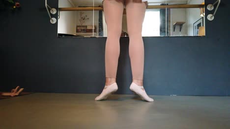 on tiptoe, exercise position stunning dog cam of a ballerina with white skirt and golden body at slow motion foto video shoot in berlin urban ballet studio