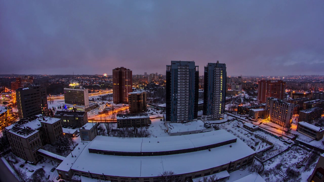 La città di Kharkiv dall'alto, timelapse di transizione dal giorno alla notte in inverno. Vista aerea del centro città e dei quartieri residenziali. Ucraina.