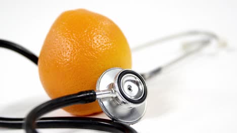 stethoscope and orange fruit on a white background