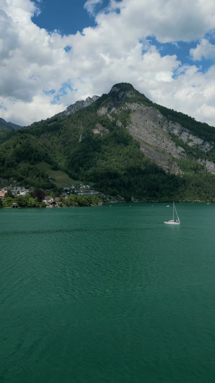 Walensee lake turquoise color water aerial drone vertical video sailing boats Switzerland summer