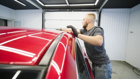 worker polish a red car. car detailing - men are using machinery car polishers maintenance to remove marks repair according to the surface of the car's paint before continuing to coat the ceramic