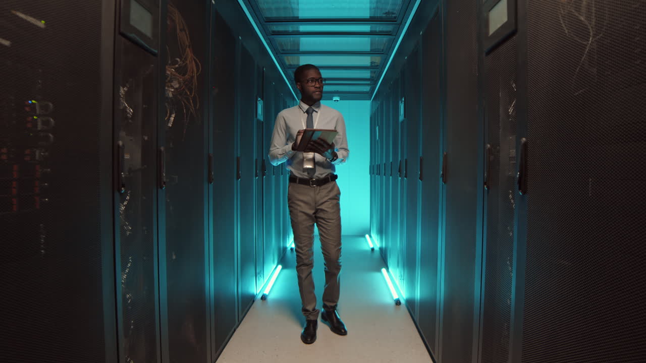 IT Specialist Walking along Row of Operational Server Racks