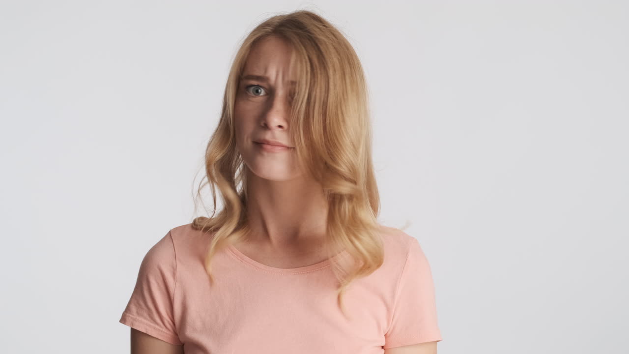 Caucasian woman waving no with the head on camera.