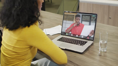 video de una mujer afroamericana haciendo una videollamada en una computadora portátil con un compañero de trabajo afroamericano