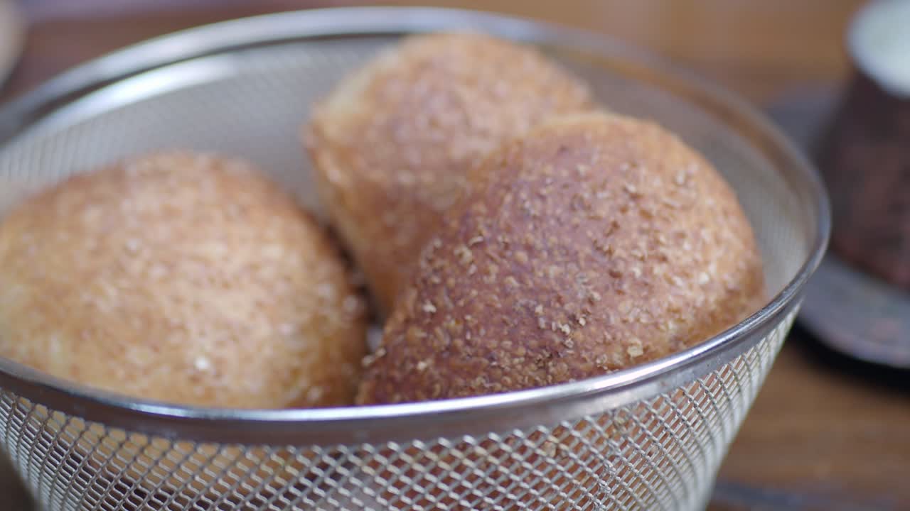 금속 바구니에 새로 구운 전체 밀 롤