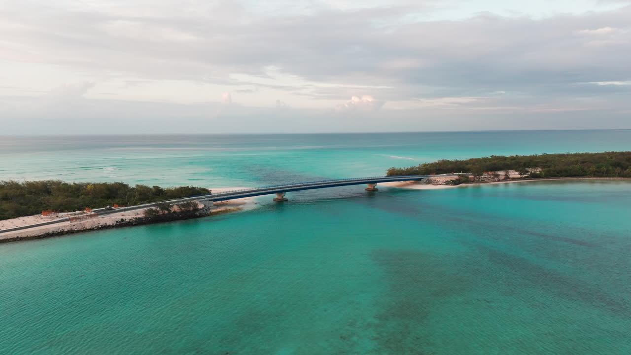 Aerial view of Lekini Bridge in Ouvéa, New Caledonia, spanning turquoise lagoon waters between sandy beaches