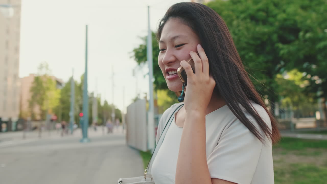 Woman talking on the phone in the city park