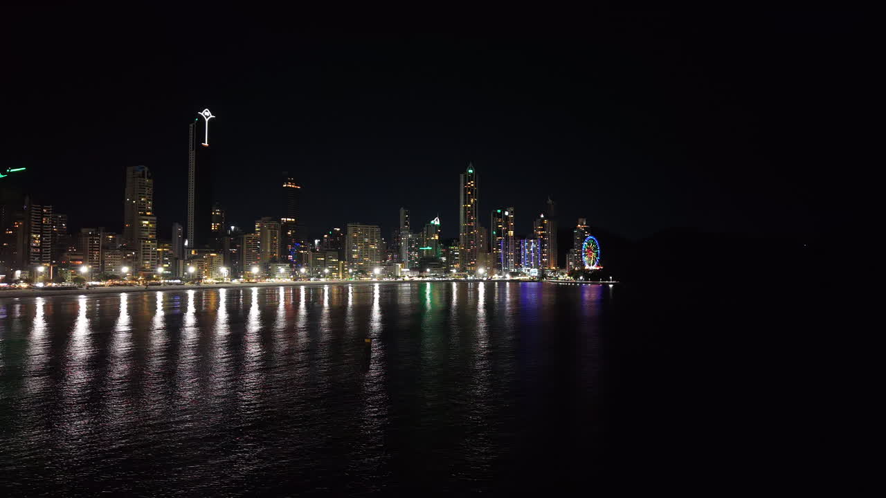 Aerial View of the Brazilian coastal city of Balneário Camboriú, with its array of skyscrapers illuminated during nocturnal hours