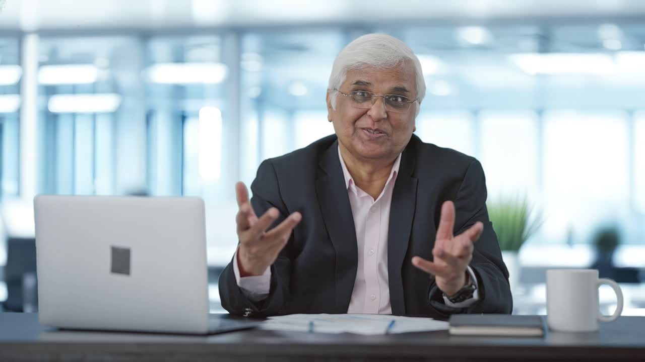Happy senior Indian businessman talking to someone