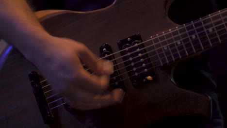 band guitarist playing in a low light venue in 4k close up