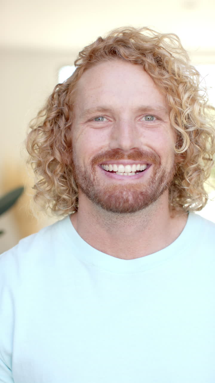 Vertical video of portrait of happy caucasian man at home in slow motion
