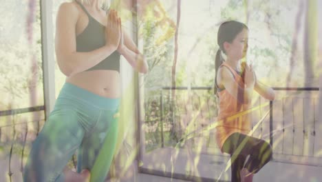 Animation-of-grass-moving-over-happy-caucasian-woman-with-her-daughter-doing-yoga