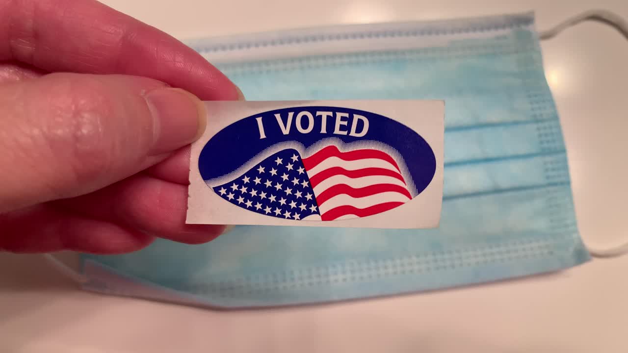 "I VOTED" sticker over a blue surgical mask