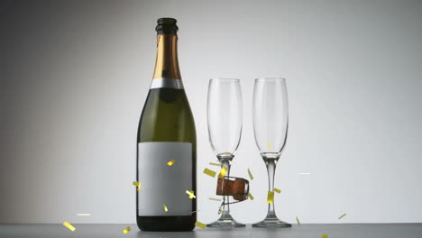 animación de confeti dorado y corcho cayendo sobre botella de champán y vasos sobre fondo gris