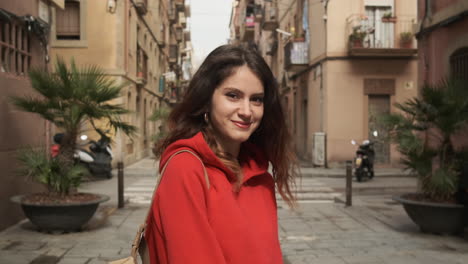 une jeune fille souriante et regardant la caméra dans la rue