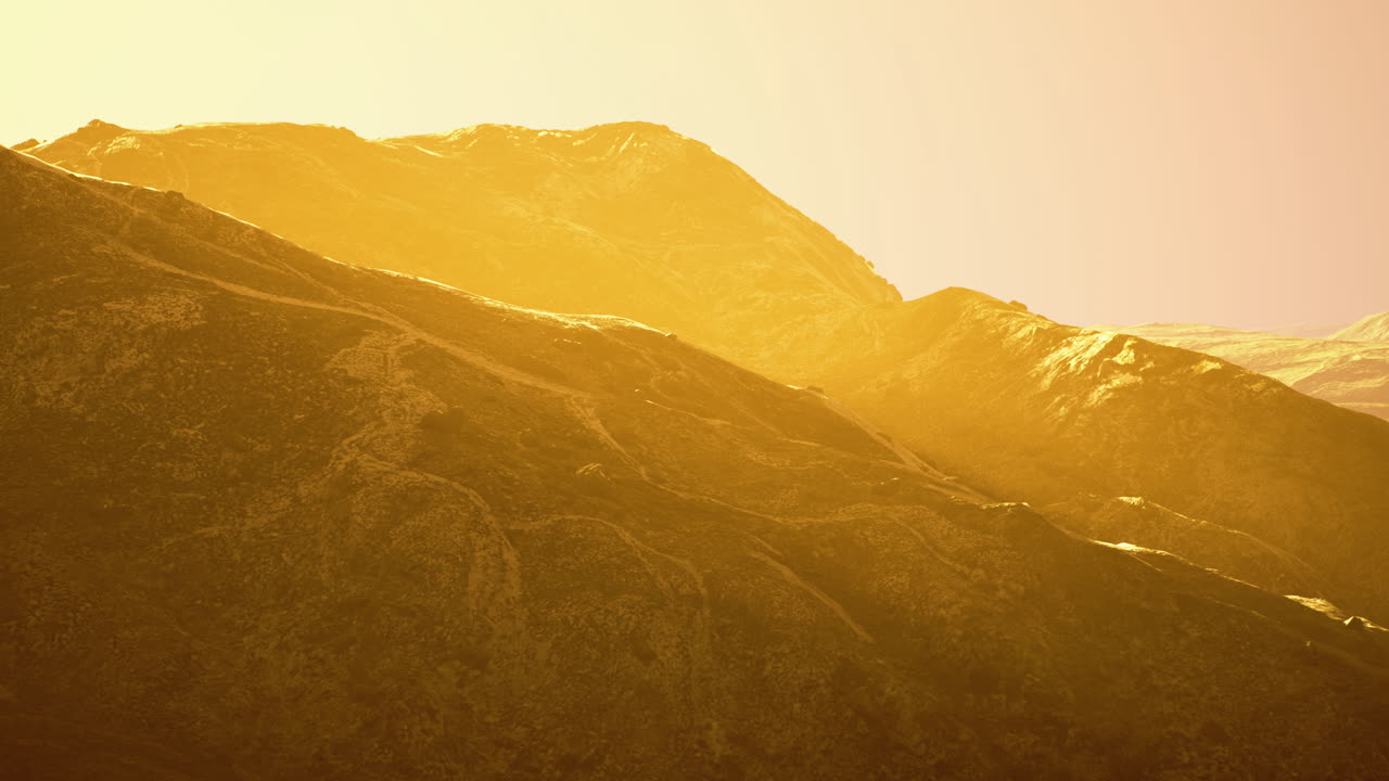 Golden sunlight illuminating rugged mountain landscape during sunset hours