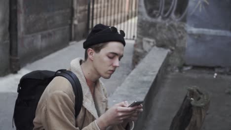 young man writing sms on mobile phone