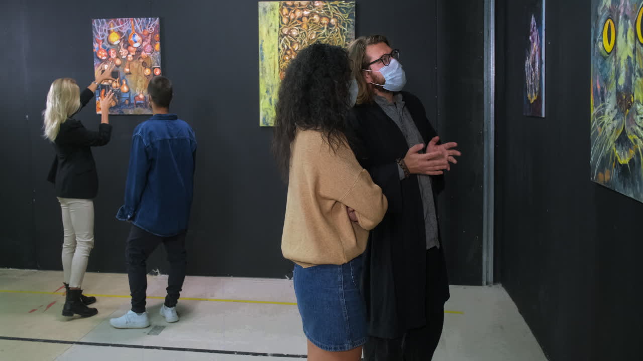 visitantes de la galería de arte viendo pinturas