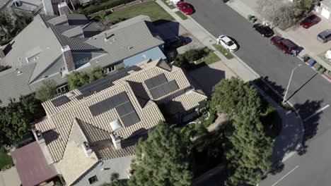 aerial orbit view, residential neighborhood with solar renewable panels on roof