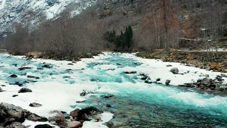 aerial across and along frozen river and across a small bridge in norway