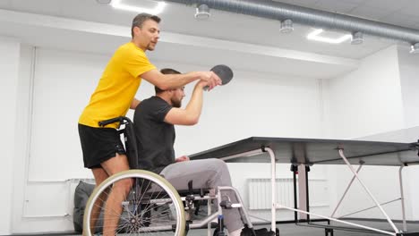 young a disabled man in a wheelchair trains in the gym disabled man training in the gym of rehabilitation center rehabilitation of the disabled