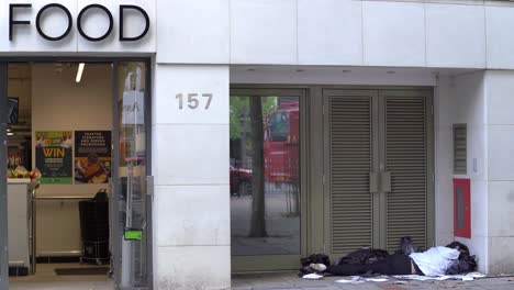 a homeless person sleeping in a high street doorway in wanstead, london