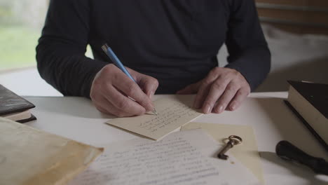 a man writes a letter with a ballpoint pen