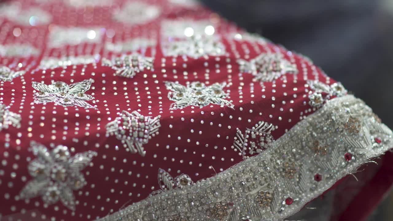 Primo piano di perline e paillettes su un sari fatto a mano, abito da sposa tradizionale in India e Pakistan