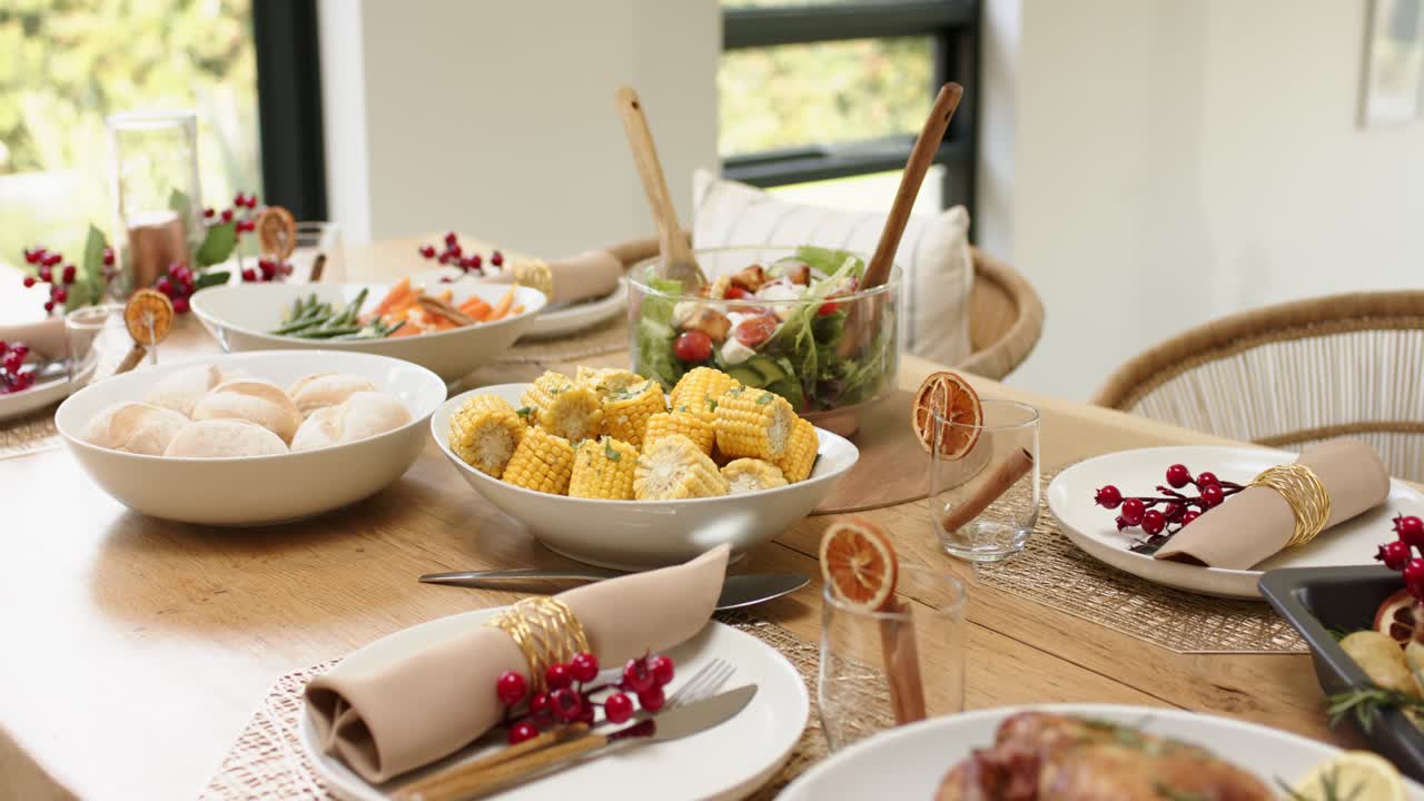 Camera is starting close on chicken platter and is panning to showcase festive table at window